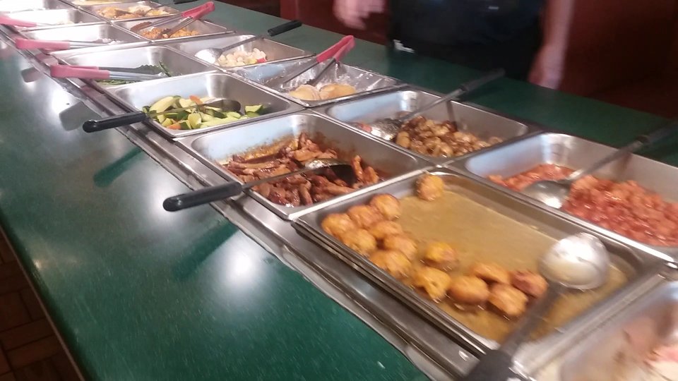 Buffet counter with trays of Chinese dishes